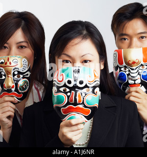Portrait de deux femmes d'affaires et d'un businessman holding masks Banque D'Images