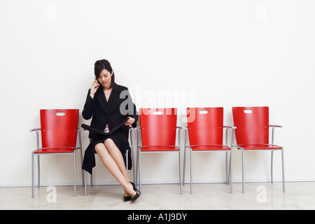 Businesswoman holding un fichier et de parler sur un téléphone mobile Banque D'Images