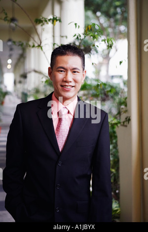 Portrait of a businessman standing dans le couloir et souriant Banque D'Images