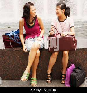 Deux jeunes femmes parlant près d'une fontaine Banque D'Images