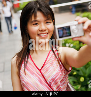 Close-up of a young woman taking a photo d'elle-même Banque D'Images