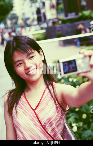 Close-up of a young woman taking a photo d'elle-même Banque D'Images