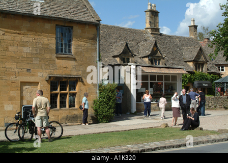 Les touristes reste et se mêlent dans Main Street Worcestershire Broadway Cotswolds Angleterre Royaume-Uni UK Banque D'Images