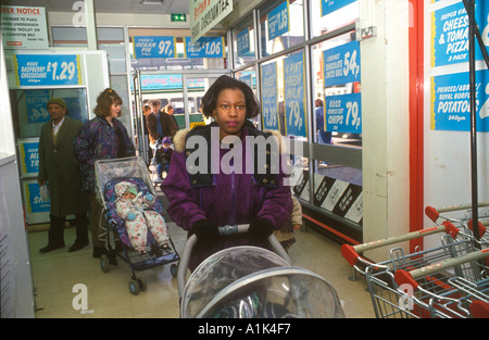 Les femmes et les bébés bargain shopping dans un supermarché dans le nord de ville en Angleterre. Banque D'Images