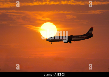 Silhouette d'air plane dans un coucher de soleil dans la soirée, comme il se prépare à la terre Banque D'Images