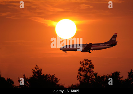 Silhouette d'air plane dans un coucher de soleil dans la soirée, comme il se prépare à la terre Banque D'Images