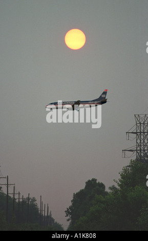 Silhouette d'air plane dans un coucher de soleil dans la soirée, comme il se prépare à la terre Banque D'Images