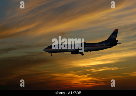 Silhouette d'air plane dans un coucher de soleil dans la soirée, comme il se prépare à la terre Banque D'Images