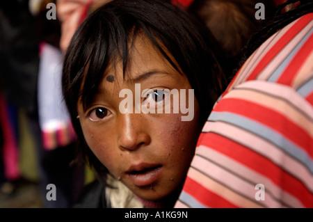 L'enfant tibétain avec d'autres pèlerins line jusqu'à rendre hommage à la Temple du Jokhang à Lhassa au Tibet 19-OCT-06 Banque D'Images