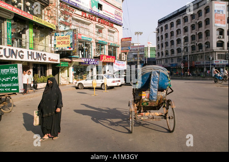 Une femme vêtue d'une burka promenades en face d'un centre commercial à Gulshan Dhaka Bangladesh Banque D'Images