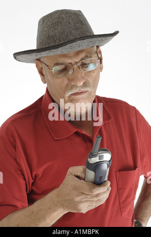 Senior citizen wearing hat numéro de composition on mobile phone Banque D'Images