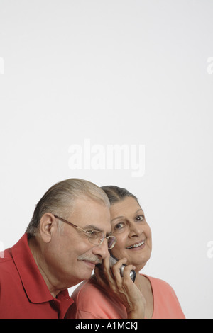 Couple Senior citizen indiennes sur téléphone sur fond blanc Banque D'Images