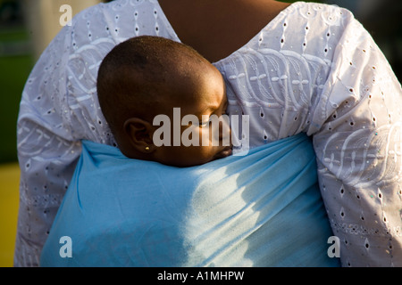 Bébé porté par sa mère dans une rue proche du marché des artisans,Bamako,Mali, Afrique de l'Ouest Banque D'Images