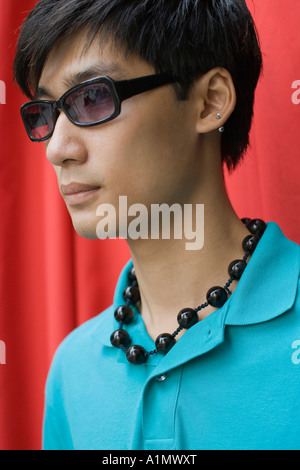 Jeune homme portant des lunettes de soleil grand et perles Banque D'Images