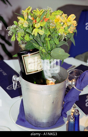 Bouteille de champagne vide avec bouquet de fleurs en metal bucket Banque D'Images