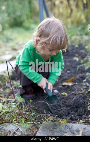 Jeune fille de creuser dans le jardin. Banque D'Images