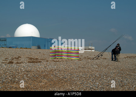 La centrale nucléaire de Sizewell B est dotée d'une sphère dôme blanche avec la plage et les gens qui pêchent en gros plan derrière une pause-vent Suffolk East Anglia Angleterre Royaume-Uni Banque D'Images