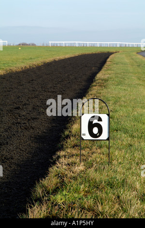 Polytrack galops dans le Nord de la région des Cotswolds Gloucestershire au-dessus du village de cheval de Ford en formant six furlong marker Banque D'Images