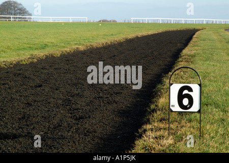 Polytrack galops dans le Nord de la région des Cotswolds Gloucestershire au-dessus du village de cheval de Ford en formant six furlong marker Banque D'Images