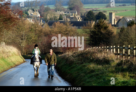 Poney et cavalier sur un rein sur un chemin de campagne dans le nord de la région des Cotswolds Gloucestershire dans la campagne anglaise UK Banque D'Images