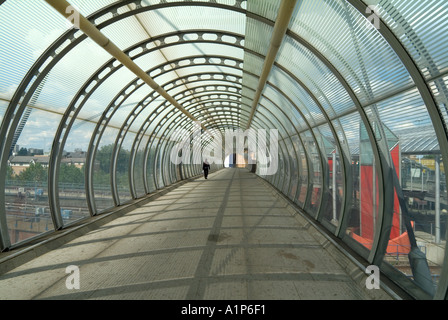 Passerelle piétonne à l'intérieur d'acier translucide structure tubulaire traversée du tunnel de la ligne de chemin de fer Banque D'Images