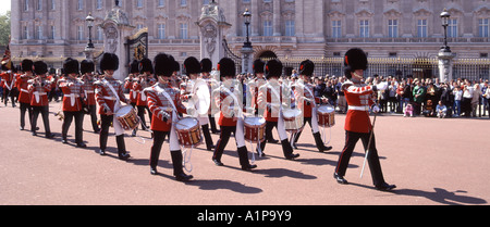 Des foules de gens à la cérémonie de changement de garde régiment de gardes britanniques Musiciens marchant en uniforme de cérémonie au Buckingham Palace Londres Angleterre ROYAUME-UNI Banque D'Images