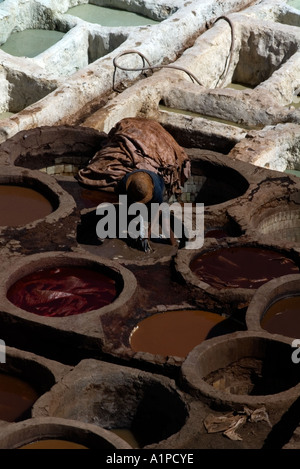 L'homme travaillant dans les cuves à mourir les tanneries de Fès, Maroc Banque D'Images
