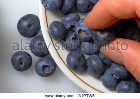 Prise d'une blueberry d'un plat Banque D'Images