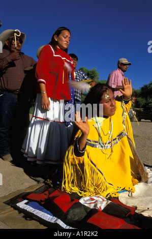 Une fille danse dans un Apache en position agenouillée à son lever du soleil danser sur la réserve indienne de San Carlos, Arizona USA Banque D'Images