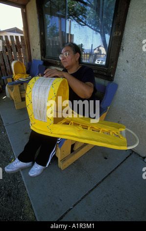 Une femme Apache décore un berceau bébé traditionnel avec des perles sur la réserve indienne de San Carlos Apache en Arizona USA Banque D'Images