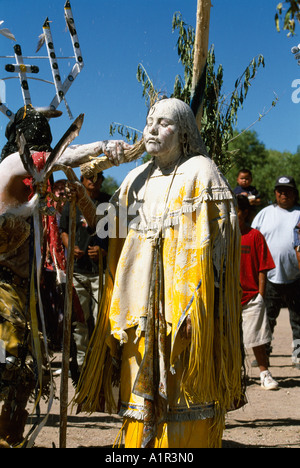 Fille d'Apache est peint avec de l'argile sacrée et de la farine de maïs au cours de sa Danse Lever du soleil sur la réserve de San Carlos, Arizona, USA Banque D'Images