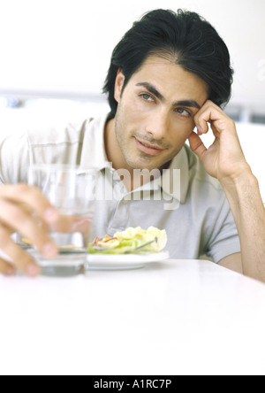L'homme assis à table, having meal Banque D'Images