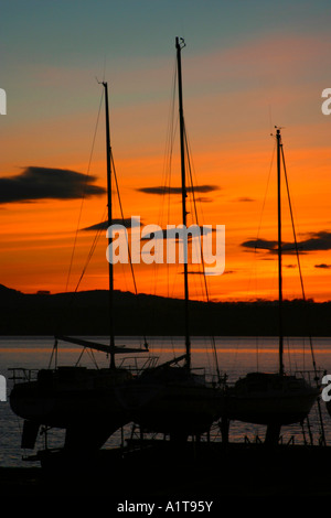 Yachts silhouetté contre un coucher de soleil paisible Banque D'Images