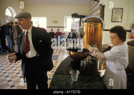 Homme buvant un verre d'eau de soufre, il est censé nettoyer une gueule de bois et nettoyer le corps. Comté de Lisdoonvarna Clare Eire. 1990s. HOMER SYKES Banque D'Images