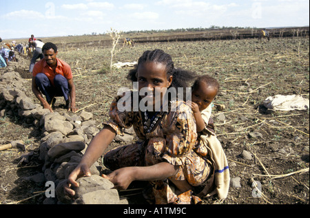 Femme avec enfant DES CAPACITÉS DE L'ÉROSION DES MURS AVEC DES PIERRES DANS L'ÉRYTHRÉE MAI 1993 Banque D'Images