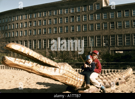 Enfants jouant SUR LA SCULPTURE DE CROCODILES DANS L'AVANT DU BLOC DE BUREAU EST DE L'ALLEMAGNE BERLIN Banque D'Images