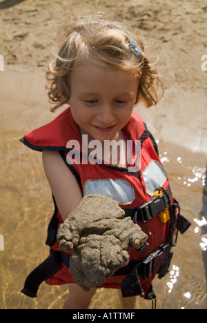 Little girl holding sand and smiling Banque D'Images