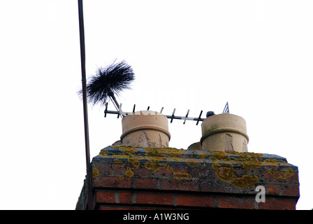 Pinceau de balayage qui sort du pot de cheminée, UK Banque D'Images