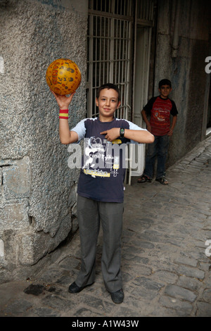 Garçon et le football à Pierre Perret. Le centre-ville de Diyarbakir, Turquie Banque D'Images