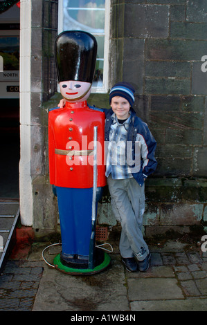 12yr old boy debout à côté d'une statue en bois de la taille de la vie d'un soldat,montent la garde à l'Churnet Valley Railway Center Banque D'Images