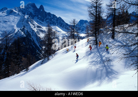 Ski en groupe hors piste à travers les arbres près de Chamonix France Banque D'Images