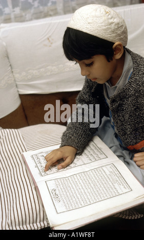 Garçon musulman lecture prières à Ramadan à la maison Banque D'Images