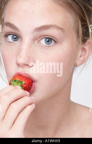 Portrait of a young woman eating strawberry Banque D'Images