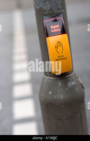 Bouton poussoir jaune à un passage pour piétons avec écrit en allemand Banque D'Images