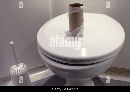 Rouleau de papier toilette fini sur un siège de toilette fermé dans la salle de bains Banque D'Images