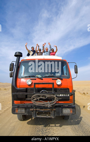 Un camion de l'aventure terrestre et ses passagers forme lorsqu'il circule à travers la réserve nationale de Paracas au Pérou. Banque D'Images