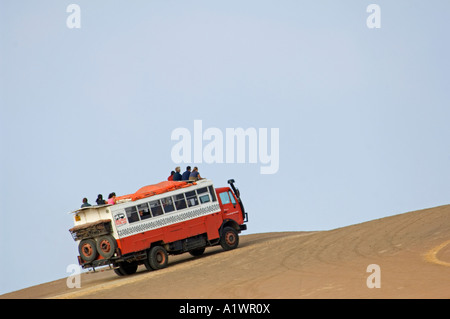 Un camion de l'aventure terrestre et ses passagers lorsqu'il circule à travers la réserve nationale de Paracas au Pérou. Banque D'Images