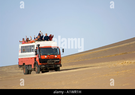 Un camion de l'aventure terrestre et ses passagers forme lorsqu'il circule à travers la réserve nationale de Paracas au Pérou. Banque D'Images