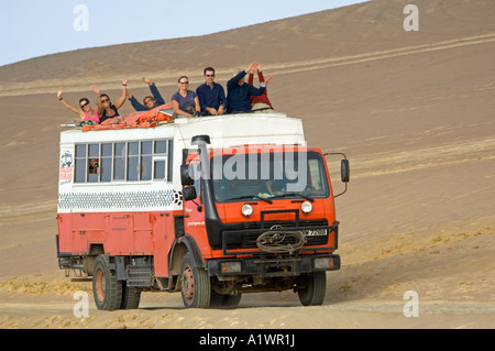 Un camion de l'aventure terrestre et ses passagers forme lorsqu'il circule à travers la réserve nationale de Paracas au Pérou. Banque D'Images