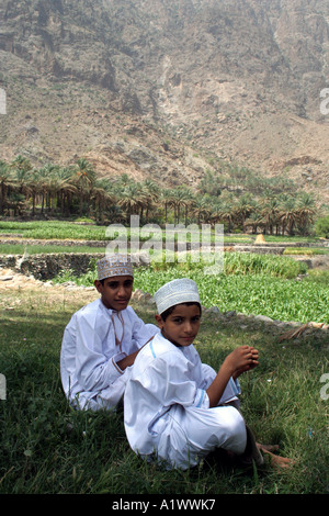 Les garçons se reposant dans l'ombre, le village de Bilad Sayt Wadi Bani monts Hajar Oman Banque D'Images